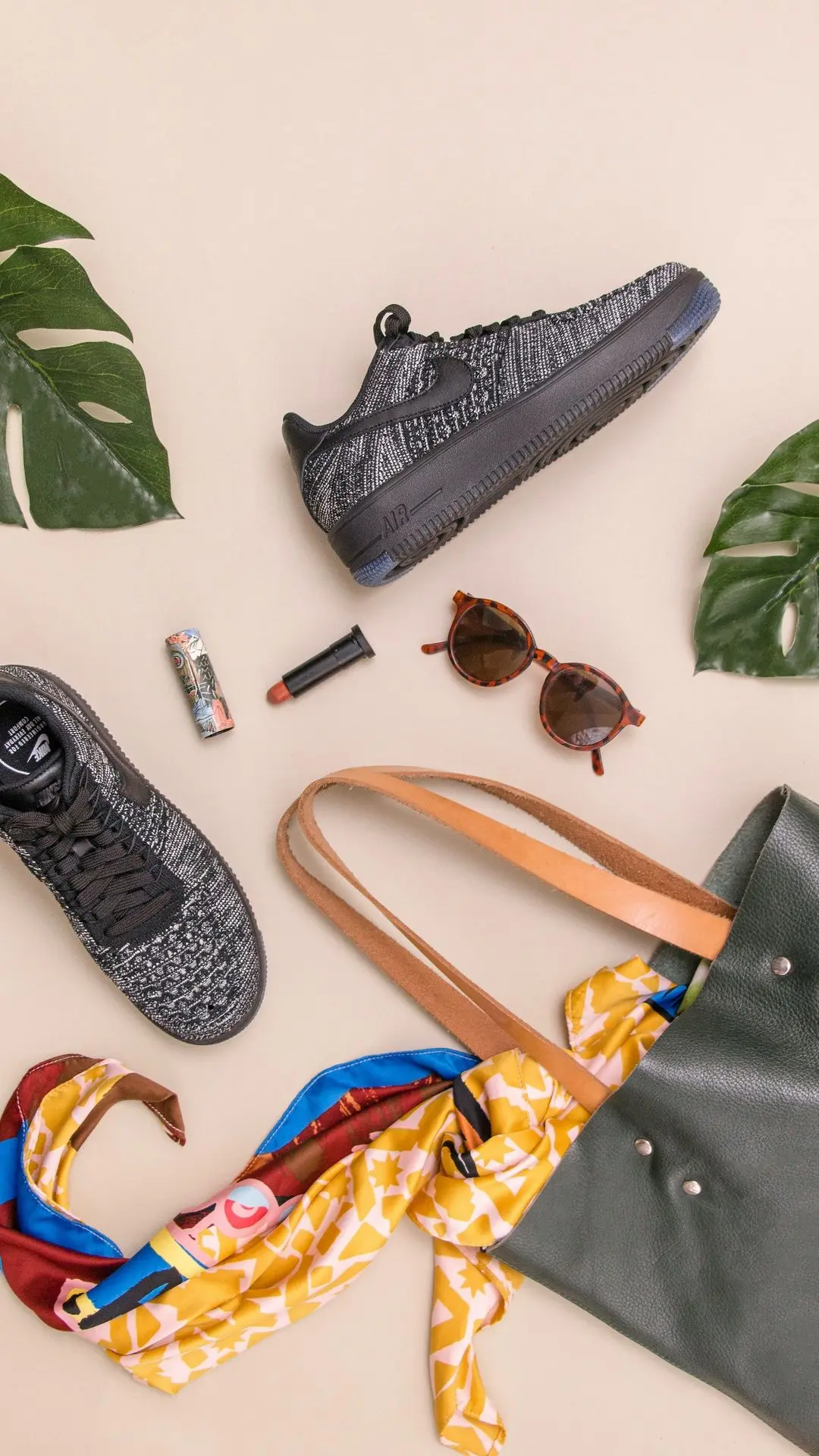 photo of bag, sneakers, and sunglasses on beige surface